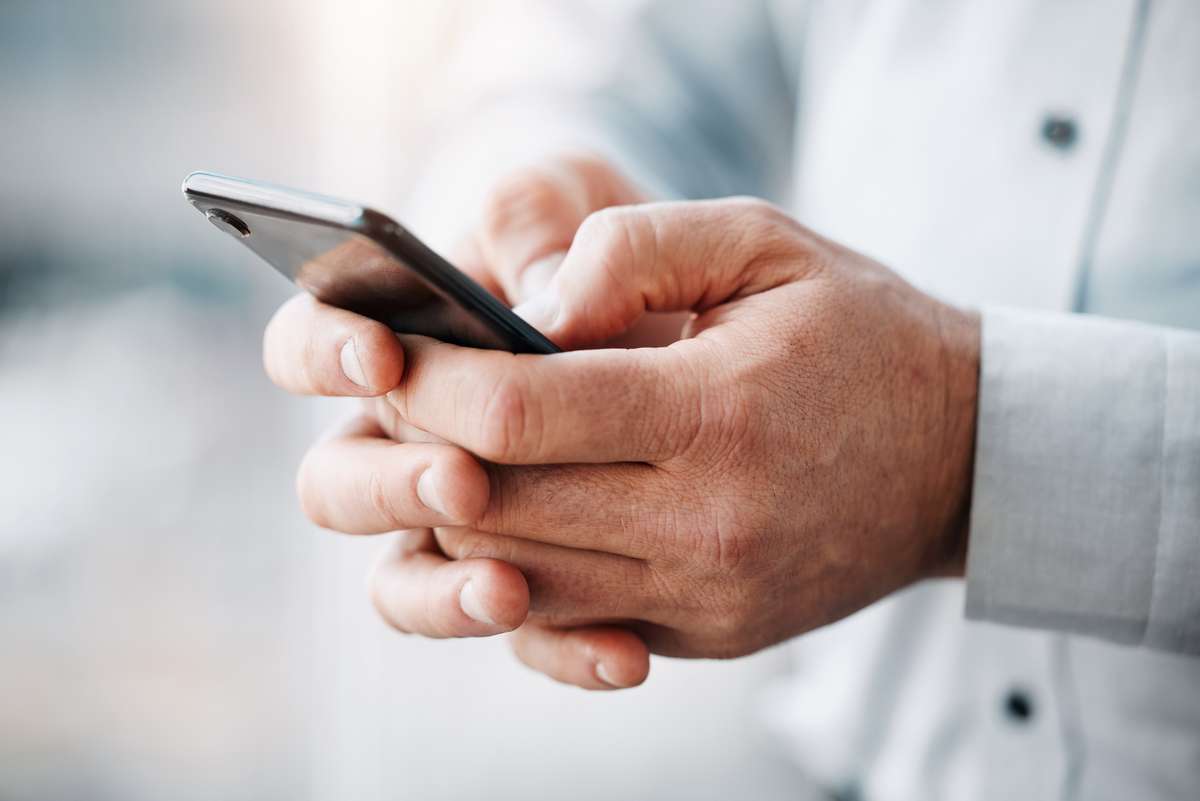 Rosenxt - Man holds mobile device to check news.