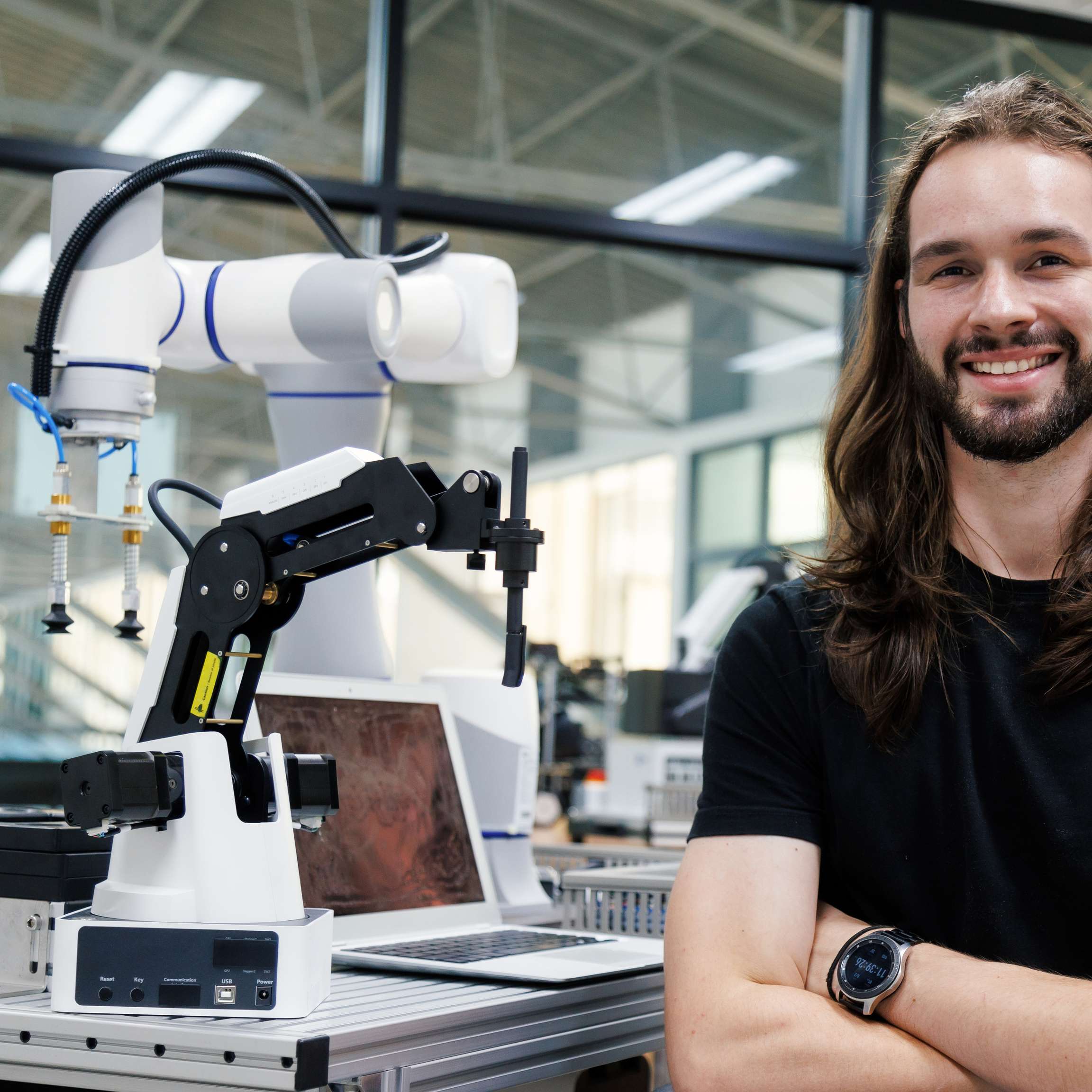 Rosenxt Employee standing next to a machine in a factory.