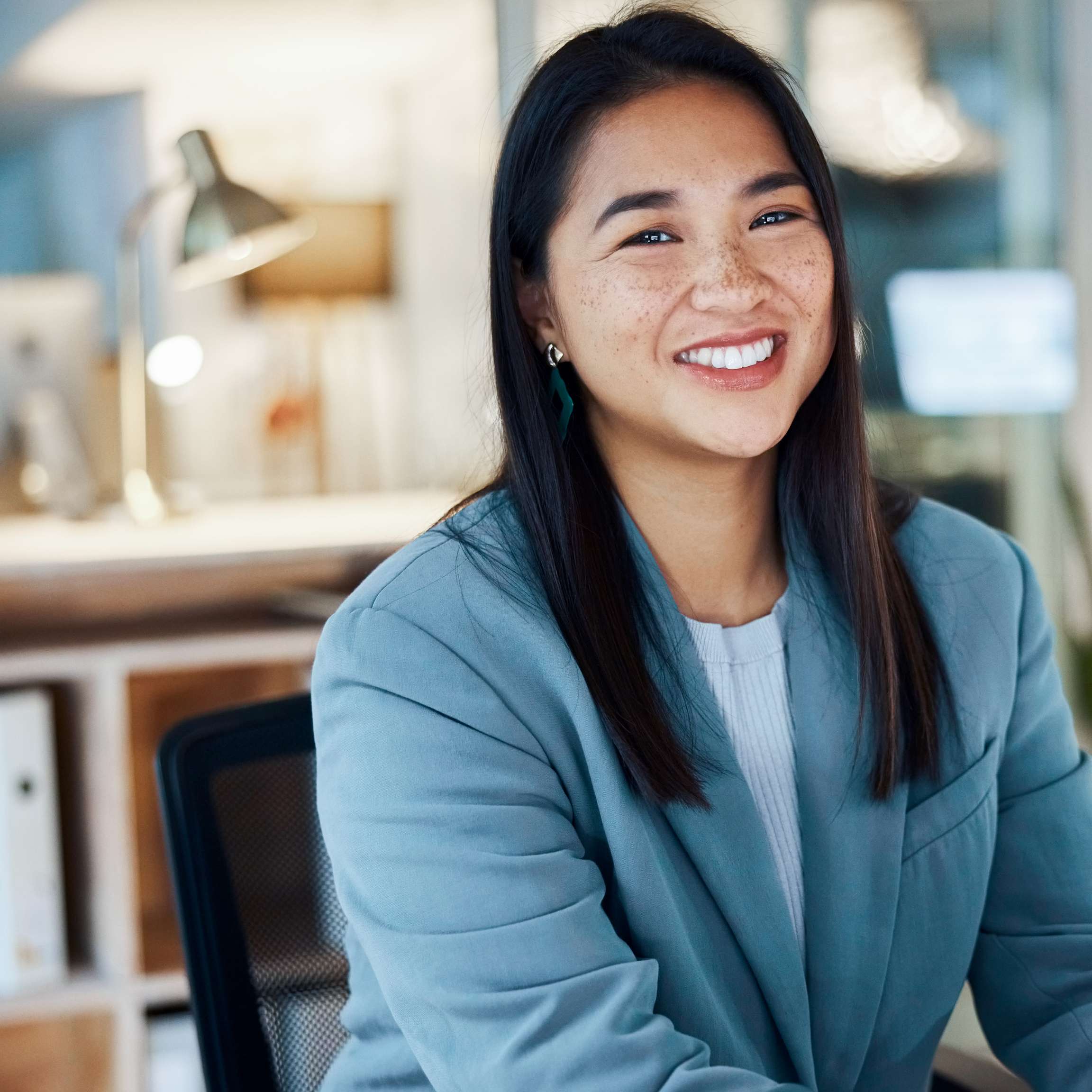 Smiling Rosenxt Employee sitting in office in front of a laptop.