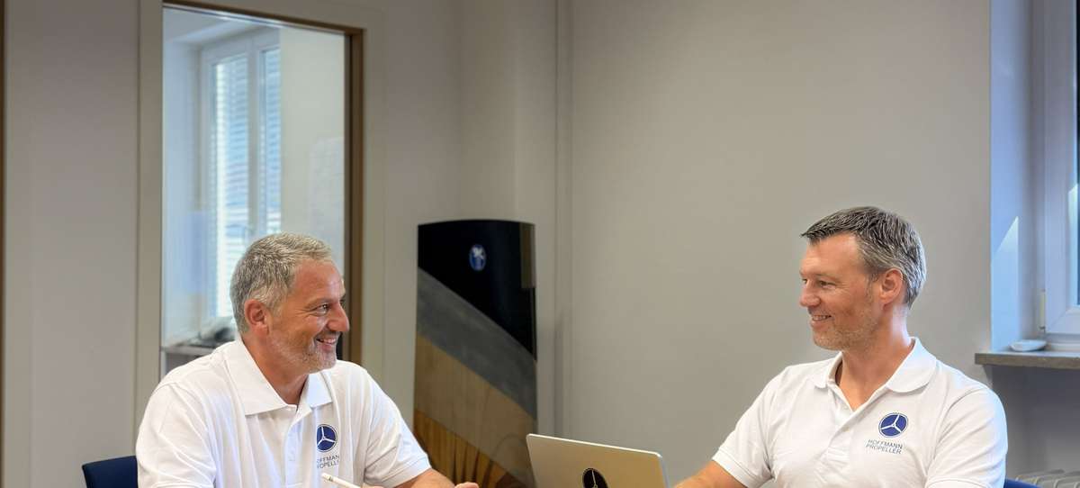 Hoffmann Propeller Managing Directors Heintje Wyczisk and Mark Härtenberger sitting at a meeting room table having a conversation. 
